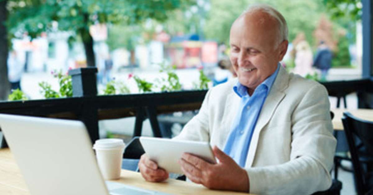 Man looking at a tablet and smiling