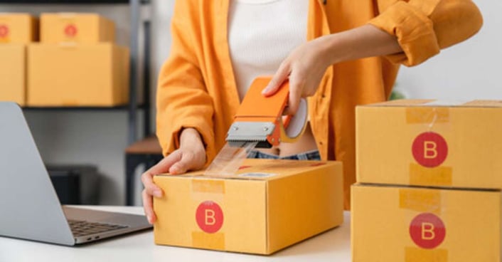 Woman taping up a box